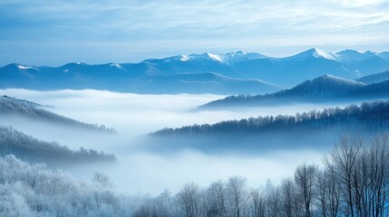 Fototapeta premium A tranquil and majestic setting of misty mountains, their snow-covered peaks barely visible through swirling fog, evoking a sense of solitude.