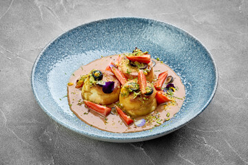 A vibrant and appetizing plate of Ukrainian syrniki, topped with fresh berries and a drizzle of sweet sauce.