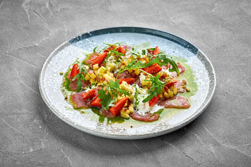 A vibrant and refreshing salad featuring thinly sliced tuna, fresh strawberries, and a zesty dressing