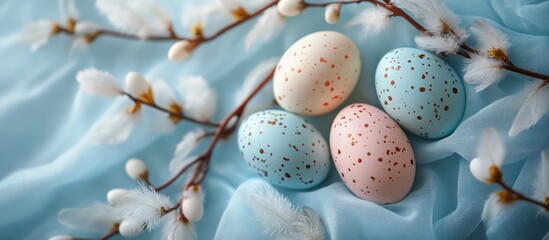 Pastel Easter eggs on blue fabric, spring blossoms