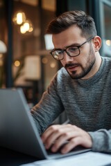 A man working on a laptop in a professional setting.