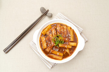Tteokbokki or Topokki, stir fried rice cake stick, popular Korean street food with spicy gochujang sauce and sesame seed. 
