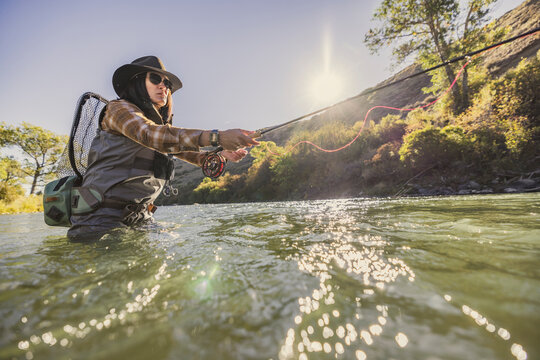 Fly fishing woman adjust her fly line