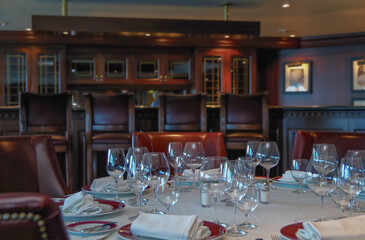 Formal and elegant Art Deco steak house speciality dining room restaurant onboard luxury cruiseship or cruise ship liner with set tables in classic interior design style and ceiling ambient lighting