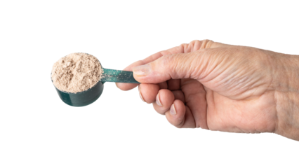 Senior female hand holding a portion of whey protein powder in a measuring spoon, isolated on a transparent background