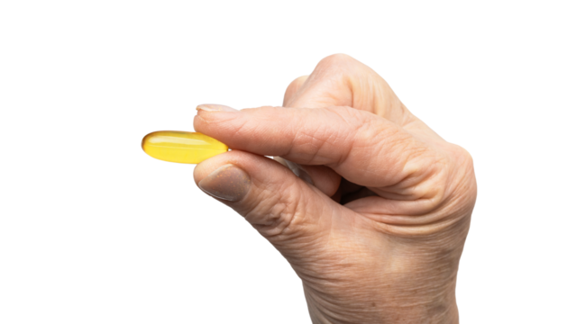 Senior female hand holding one yellow omega-3 capsule, fatty acids, fish oil supplements, isolated on a transparent background