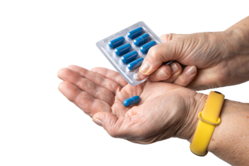 Senior female hand taking out blue medicine capsule from blister pack of prescription medication, antibiotics, painkiller pills, isolated on transparent. Healthcare, elderly care, medical treatment 