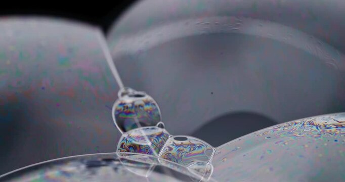 Camera slowly zooming in on freshly created soap bubbles full of intense rainbow colors