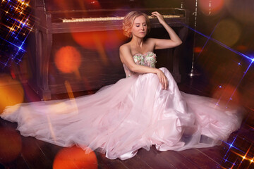 Woman in long pink dress sitting on the floor near the piano. Advertisement of musical fairy tale.