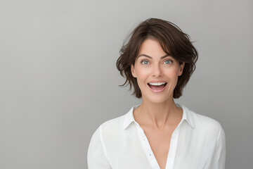 A studio portrait of a woman expressing awe, with her mouth slightly open and eyes wide
