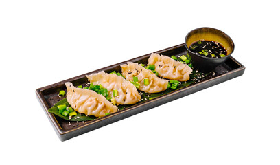 Delicious dumplings served on a sleek platter with dipping sauce and garnishes in a trendy dining...