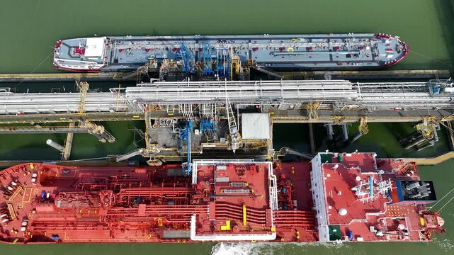 Aerial drone view of a LNG Supertankers Docked in Port Awaiting Offloading and Loading of Fuels and Cargo Petroleum Tanker Vessel Chemical or Methane freighter export import