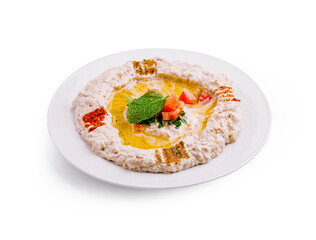 Rich and creamy tahini dip served with olive oil, herbs, and spices on a white plate