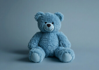 Obraz premium A blue teddy bear toy rests against a solid-color background. The simple, clean composition captures the toy's adorable charm, making it ideal for children's products or playful designs.