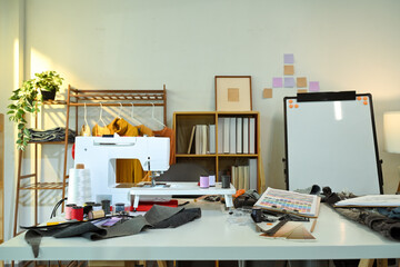 Creative fashion designer studio with sewing machine, fabric swatches and design tools