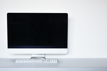 Fototapeta premium Blank computer screen with mouse and keyboard on the office desk, white background 