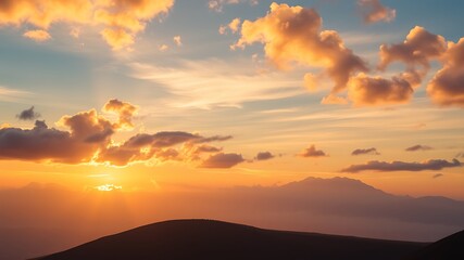 Obraz premium Golden sunset above mountain ridges creating a warm and peaceful atmosphere in nature.