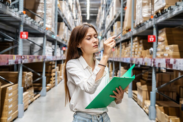 Large storage facility, Young woman diligently checking her clipboard as she organizes and oversees...