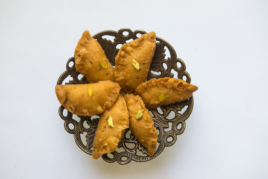 Authentic North Indian sweet -Gujia, arranged on a traditional decorative tray. Holi festival special sweets and treat.
