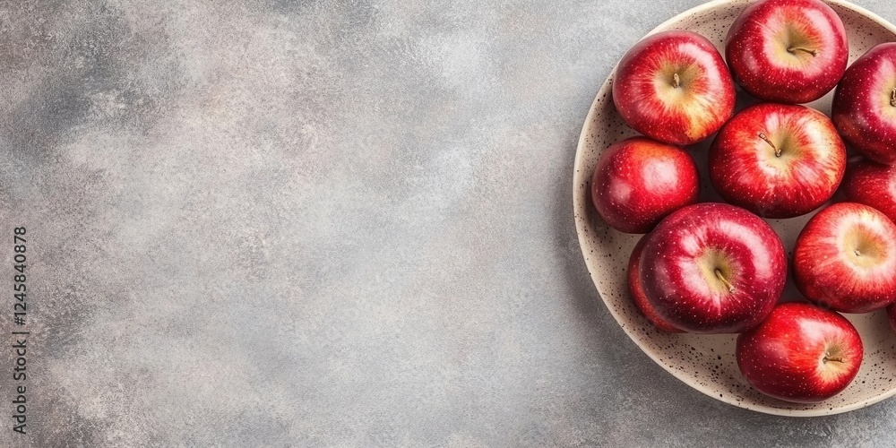 Poster Red apples in a beige bowl on a textured gray table surface with ample copy space on the left side for promotional text or designs