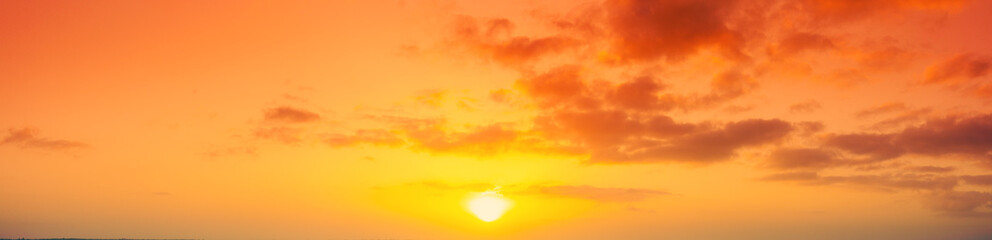 Obraz premium Panorama of the orange cloudy sky during sunset. View from above. Horizontal banner