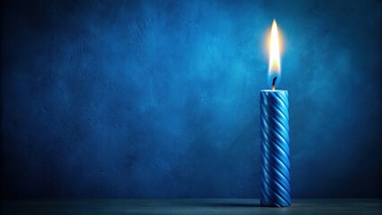 A single blue birthday candle burns on a dark blue background with subtle texture and slight gradient effect, dark blue hue, textured surface