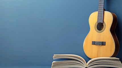 Acoustic guitar on open book against blue wall; music education concept