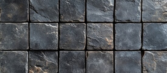 Black square paving blocks arranged in a grid pattern for pedestrian pathways Vintage textured ground flooring background and wallpaper design