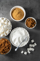 Different type of sugar, light brown, dark brown and white sugar cubes in bowls. 