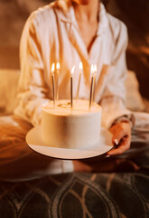 Celebrating a special moment with a beautifully decorated cake and lit candles in a cozy evening setting