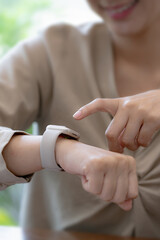 Young woman using a smartwatch to check notifications from smartphone.