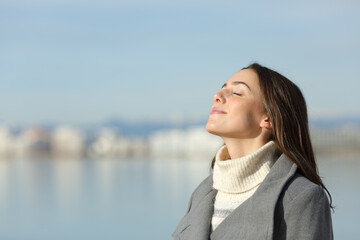 Woman in winter breathing fresh air on the beach