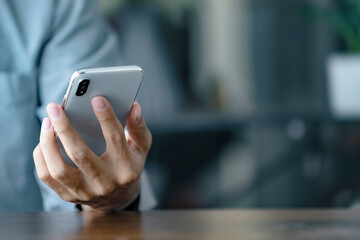Close up hands using cellphone searching on internet.