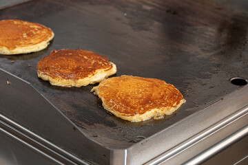 Appetizing pancakes frying on the cafe pan
