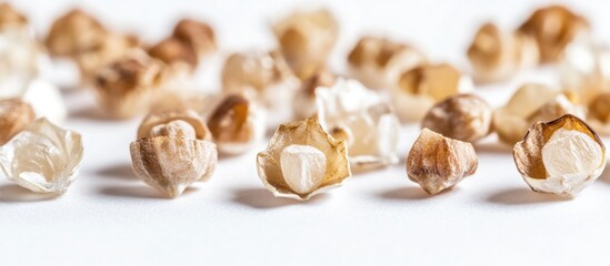 Buckwheat grains scattered on a clean white background showcasing their natural texture and color. Ideal for healthy food concepts.