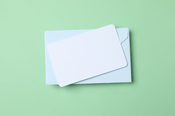 Blue envelope with white paper card on green background