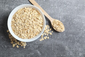 Composition with oatmeal flakes on gray background. Cooking breakfast
