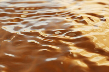 Golden liquid surface with gentle waves reflecting light