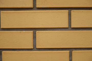Macro of sand yellow smooth brick wall with running bond