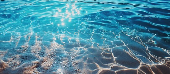 Vibrant rippling waters under the sun showcasing the beauty of crystal clear blue sea with shimmering reflections on the surface.