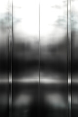 A sleek, modern elevator door with a metallic finish reflecting light and surroundings. Perfect for real estate, urban architecture, or transportation themes.