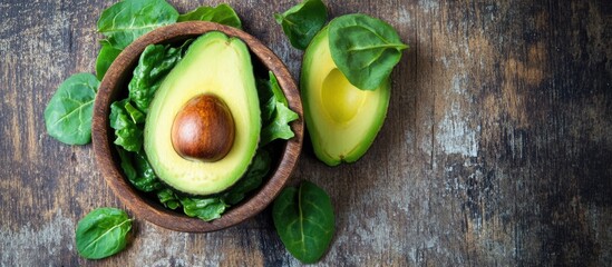 Colorful fresh salad with avocado and tomatoes alongside mortar and ingredients on rustic wooden table ideal for healthy food promotions