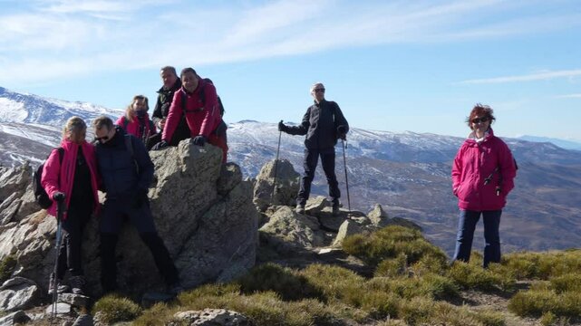 Group of hikers pausing and arranging themselves for a shot on a rocky summit in Sierra Nevada