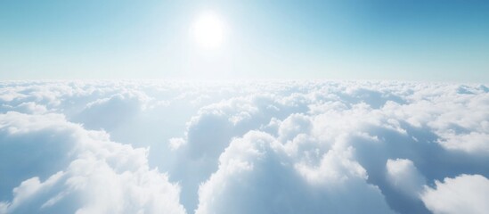 Fototapeta premium Soft fluffy clouds in a serene blue sky with sunlight creating a tranquil and idyllic panoramic nature scene.
