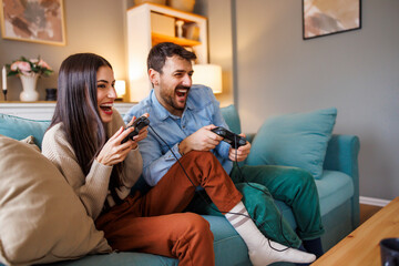 Couple excited while playing video games at home