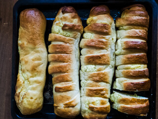A tray of four rolls of bread on a wooden table