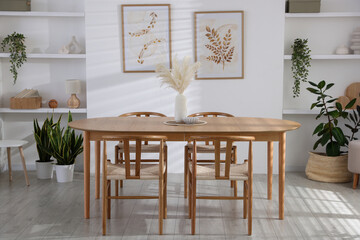 Stylish wooden table with chairs and decor indoors. Interior design