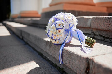 Elegant Wedding Bouquet with Blue Ribbon on a Church Entrance Step..