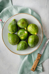 Fresh figs on a dish, placed on a stone background.