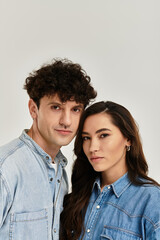 Stylish young couple showcasing trendy denim looks in a modern studio environment